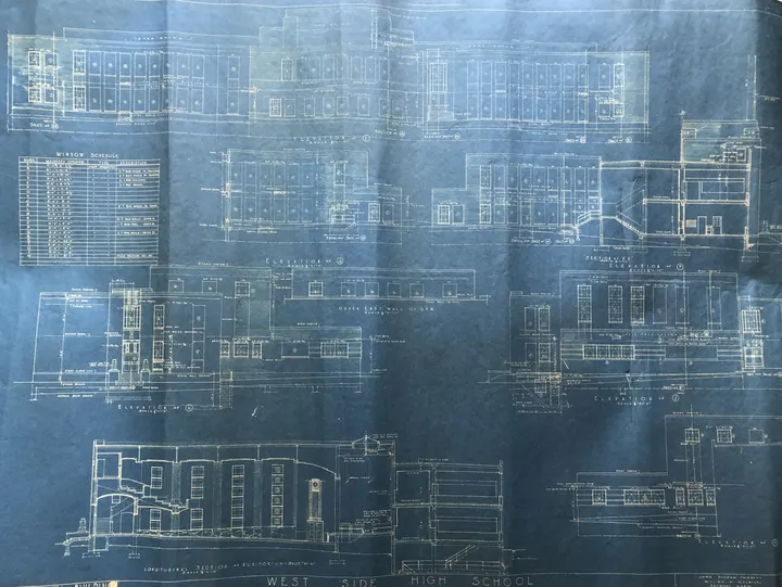 A blue architectural drawing with building plans and elevations.