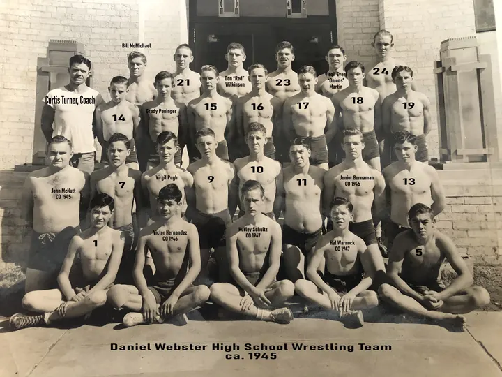 A posed Webster wrestling team photograph with identifying annotations on the print.